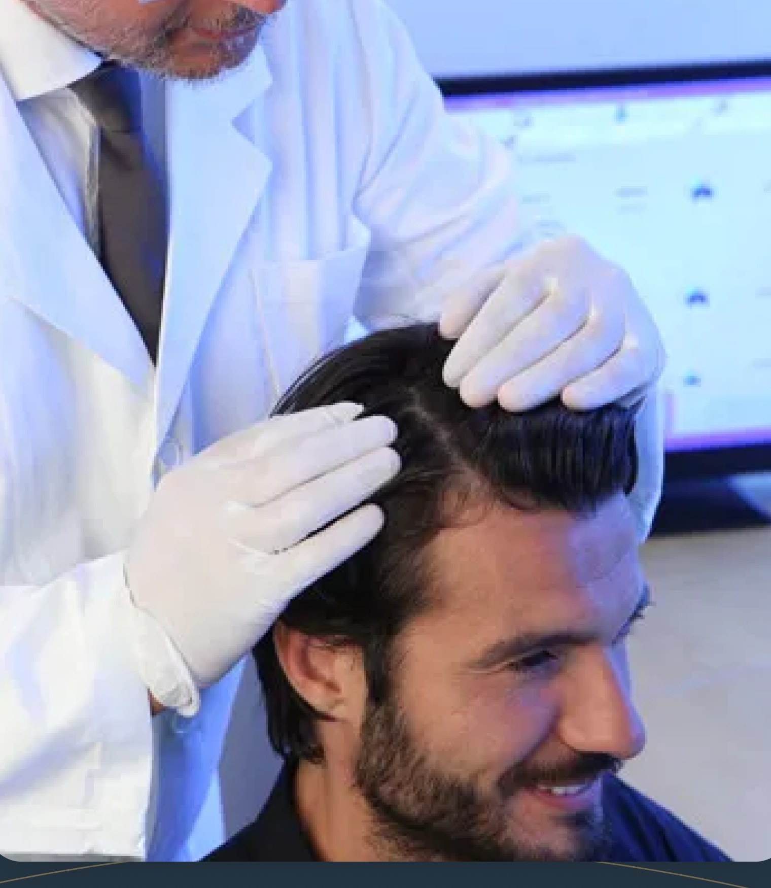 Specialist examining a man's scalp beside an analysis monitor