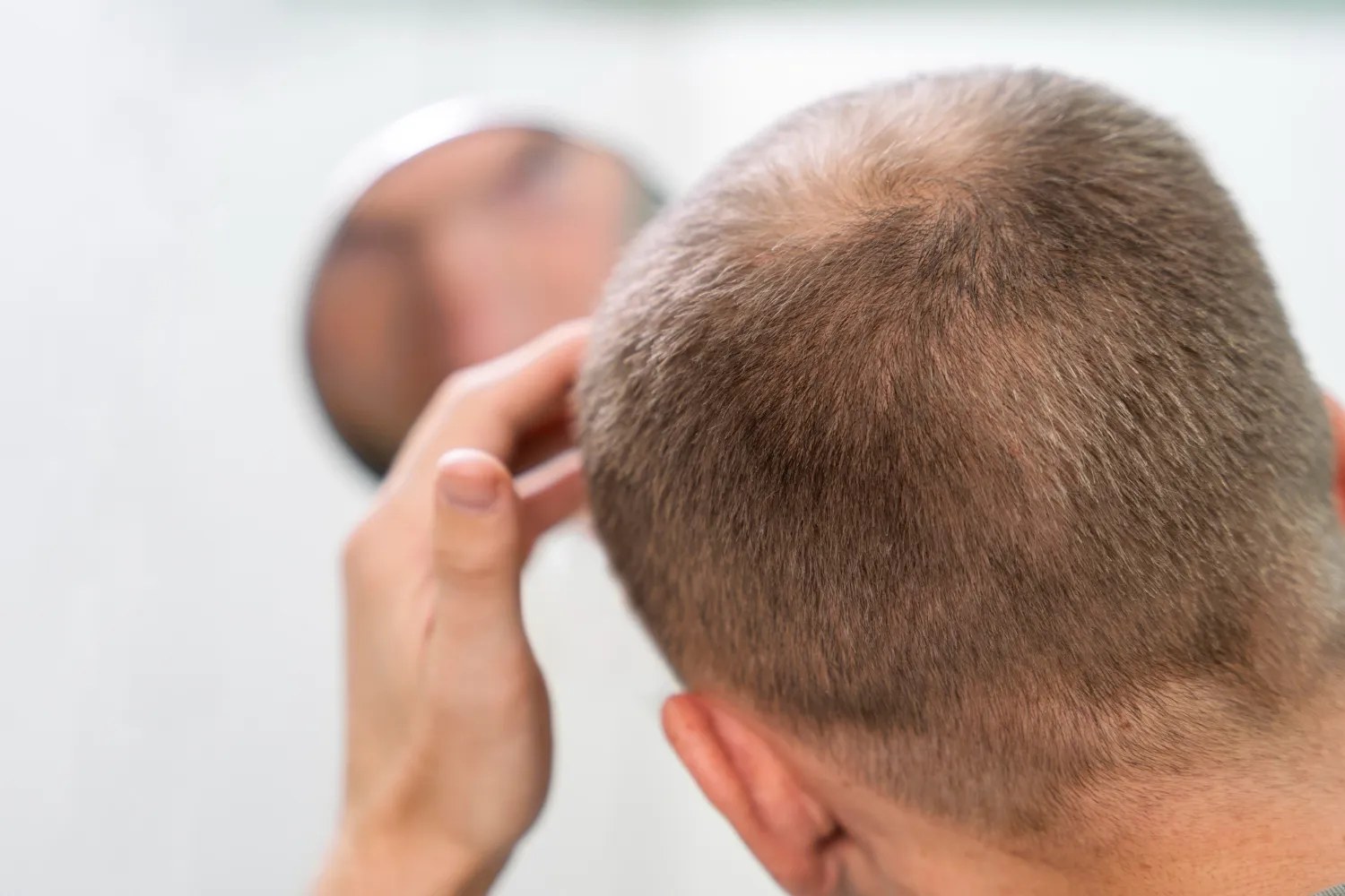 Man checking the back of his head in a mirror